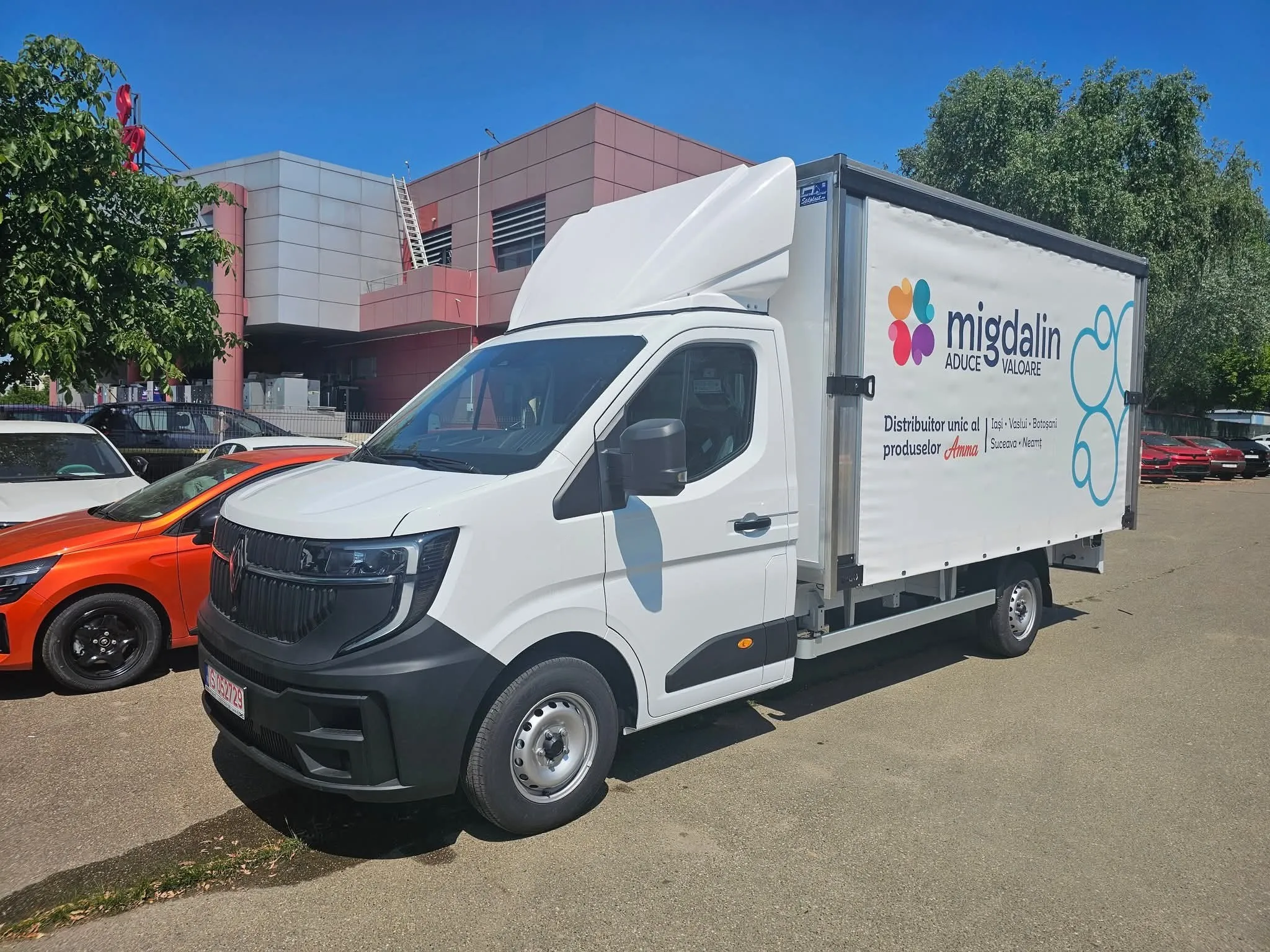 Autoutilitară Migdalin cu logo-ul actual, rozeta în patru culori, pe prelată