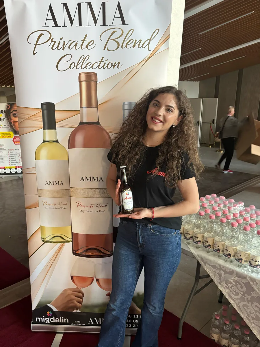 Reprezentantă Amma lângă standul cu vinurile Private Blend