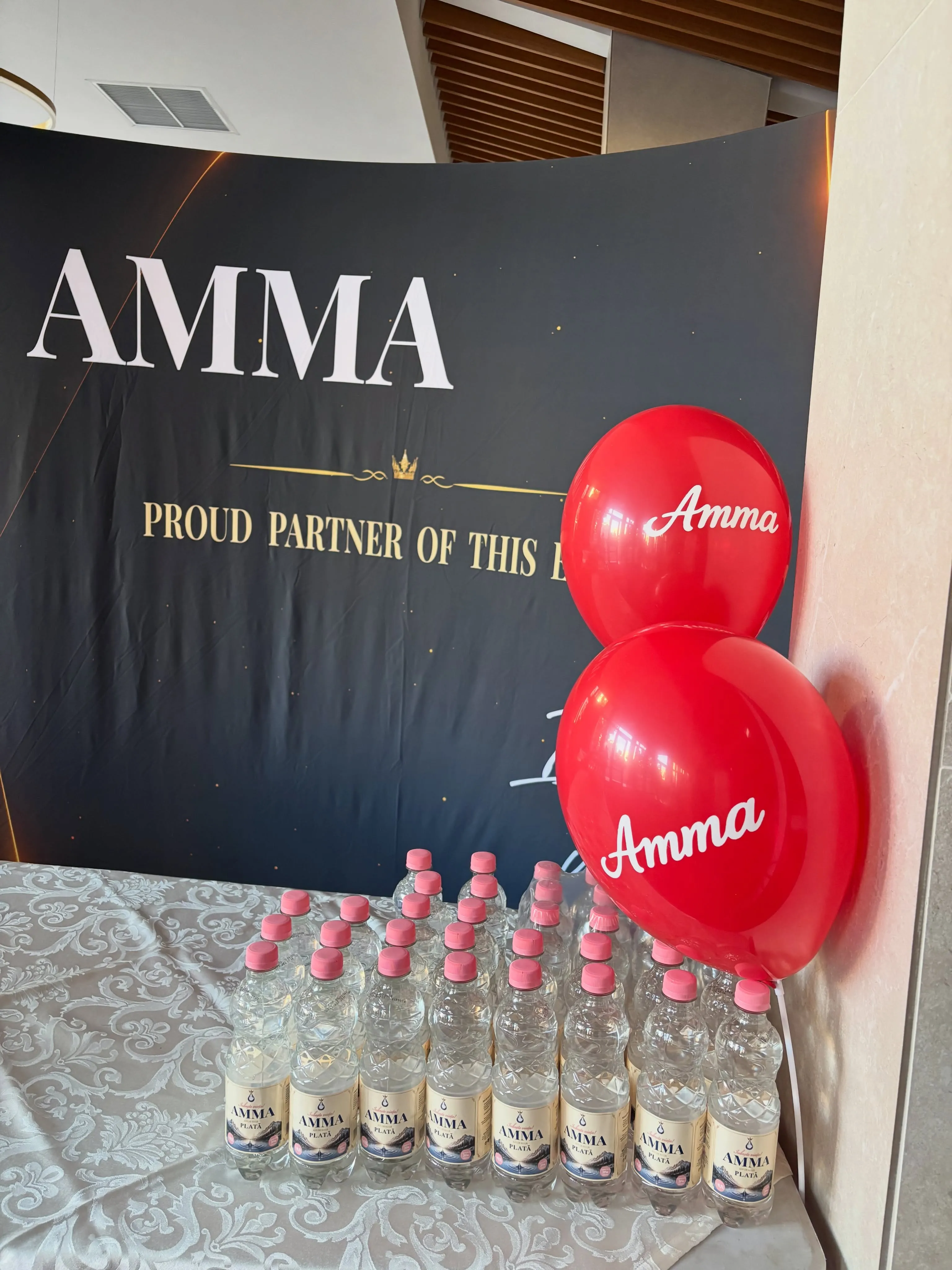 Sticle de apă Amma și baloane roșii Amma, la stand